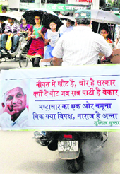 A supporter of Anna Hazare carries a placard on his scooter in Ranchi on Thursday