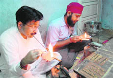 Artisans prepare nosepins at a shop in Amritsar. 