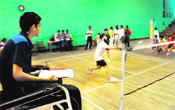 A player (sitting on chair) supervises a match as a chair umpire during the Inter-School Badminton Championship in Chandigarh