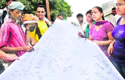 Youth get the signatures of a hawker on a long canvas in support of Anna Hazare at BMC Chowk in Jalandhar