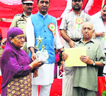 Yog Raj Thakur (right) and his wife, Usha Thakur, being felicitated by Minister for Tourism Nawang Rigzin Jora in Doda.