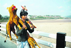 A boy carries decorative items for sale in the market in Jammu.