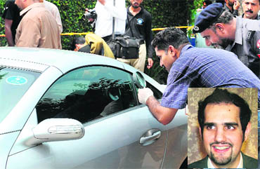 A policeman examines the car of Shahbaz Taseer (right) in Lahore on Friday.  AFP 