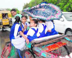 An umbrella fails to protect schoolchildren from rain.