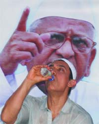 Bollywood actor Aamir Khan drinks water to break his fast during Ramadan at the Ramlila Maidan in New Delhi on Saturday