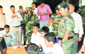 Students of Government Boys Higher Secondary School, Sunderbani in Rajouri, use a computer in the presence of the officers of the Kalidhar Brigade of the Army on Saturday. 