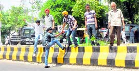 People cross a divider to reach the other side of the road.