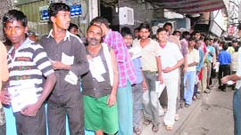 Labourers line up to get their dues at the sweetmeat shop.