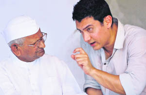 Bollywood actor Aamir Khan talks with Anna Hazare on the 12th day of his fast at the Ramlila Maidan in New Delhi
