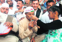 A girl offers juice to Laxmi Chand in Shimla on Sunday.