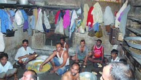 Not So sweet: Workers seated on the floor and with their clothes hanging on the walls seen preparing eatables at Lovely Sweets in Jalandhar