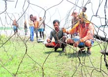 Workers prepare iron nets at dhussi bundh in Shahkot; (below) belongings kept on the rooftop of a house in Fazilka.