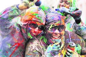 COLOURS OF FESTIVITY: Revellers react after being sprayed with paint during the Notting Hill Carnival in London on Sunday