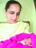 A worker of the Red Cross Society holds a girl child, who was left by some unknown woman at Pangura in Amritsar