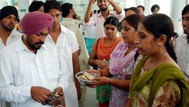 Employees of the NRHM beg from people to lodge a protest at the Civil Hospital in Bathinda on Monday.