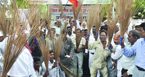 Activists of the Akhil Bharatiya Safai Majdoor Sangh carry brooms and shout slogans in support of their demands in New Delhi 