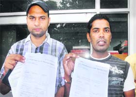 Prem Lal and Ripan Kumar show travel documents in Jalandhar