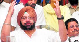 PPCC chief Capt Amarinder Singh with Gulchain Singh Charak at a press conference in Mohali on Monday.