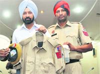 Cops show the uniform and weapons seized from the accused in Ludhiana on Monday.