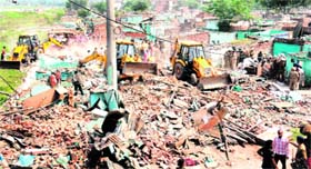 A team of the estate office demolishes structures at Shaheed Bhagat Singh Colony in Mauli Jagran on Tuesday.