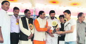 Uttarakhand Chief Minister Ramesh Pokhriyal Nishank gives an award to a student at the annual function of Laxman Singh Mahar PG College at Pithoragarh on Tuesday.