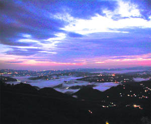 The fascinating skyline of Shimla is seen silhouetted against dark clouds. 