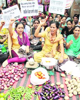 Doctors and paramedics, working under the NRHM, register their protest by selling vegetables in front of the civil surgeons office in Jalandhar on Tuesday
