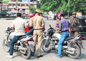 Security personnel stop motorcylists for checking in Srinagar on Tuesday