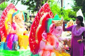 An artist gives the finishing touches to an idol of Lord Ganesha at a workshop in Jammu on Tuesday