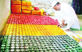 An inmate of the Kot Bhalwal Jail makes colourful candles in Jammu. 