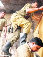 Due to paucity of ladders, firefighters are sometimes forced to use each others shoulders to cross the wall in Ludhiana