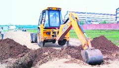 A GLADA bulldozer digs up a road in an illegal colony in Ludhiana. 