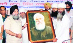 A painter presents a portrait of Bhai Kahn Singh Nabha to VC of Punjabi University Dr Jaspal Singh on his 150th birth anniversary celebrations at Punjabi University in Patiala.