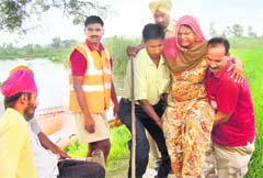 NDRF men help a woman during a rescue operation in a flood-affected village in Ferozepur.