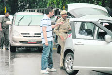 A  cop stops a vehicle for checking at Panjab University 