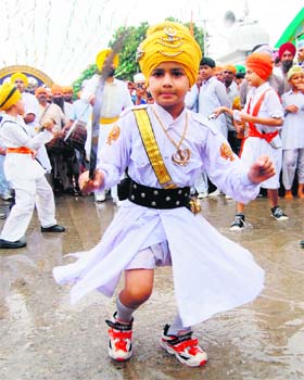 The pilgrims progress: A child displays gatka skills during a nagar kirtan taken out to mark the 407th anniversary of the installation of Guru Granth Sahib in Amritsar on Thursday