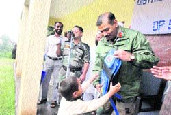 An Army officer gives a school bag to a child in Government Primary School, Niorajal, in Rajouri 