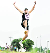 A youth takes part in the long jump event during the sub-inspectors’ recruitment rally held at PAU in Ludhiana