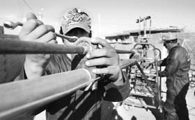 Bolivian Franklin Cancari (L) works on the tail rotor of a one-person helicopter that he, his father Jaime (R), and brother Hugo are manufacturing from recycled metal