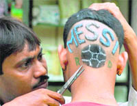 A Messi fan undergoes a special hair-cut to sport the footballers name in Howrah. 