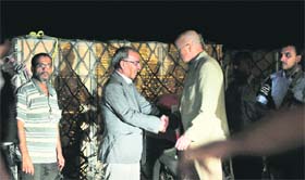 CASH FLOW: Libyan Bank Governor Qassem Azzoz (centre) shakes hands with John Jenkins, Britains ambassador to Benghazi, as they stand near crates of bank notes at Benghazi