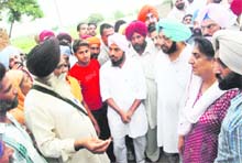 PPCC chief Capt Amarinder Singh and CLP leader Rajinder Kaur Bhattal speak to the affected farmers at Gobindpura village in Mansa district on Friday. 