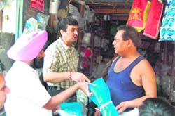 The AMC Health officials scrutinizing the polythene carry bags being used by shopkeepers, in Amritsar