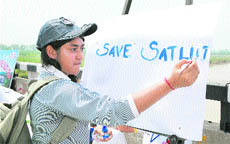 A student of BCM Arya Model Senior Secondary School, Shastri Nagar, writes a slogan on enviornment at Sutlej Bridge in Ludhiana. 