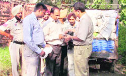 MC Medical Officer Dr Vipul Malhotra (right) along with officials of the Punjab Pollution Control Board and MC  checks the thickness of poly bags during a raid at Railway Colony in Ludhiana.  