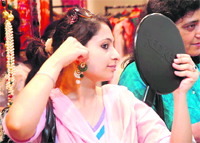A visitor tries out an earring at Bridal Asia
