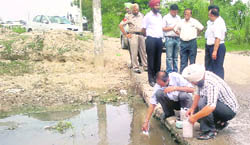 A Punjab Pollution Control Board team collects water sample from the Ghaggar. 