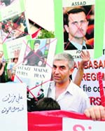 A man walks past placards during a protest march against Syria's President Bashar al-Assad organised by the Syrian minority in Bucharest, Romania. 