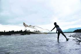 A fisherman throws his net in the Song river near Dehradun