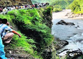 People watch the ill-fated bus that fell into the Tons river at Tyuni near Dehradun on Sunday